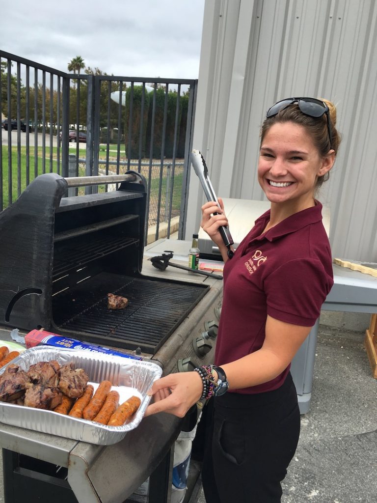 Amanda manages the grill for a recent patio BBQ for students